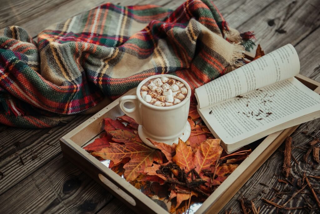 Fall themed tray with leaves, hot cocoa and a book.