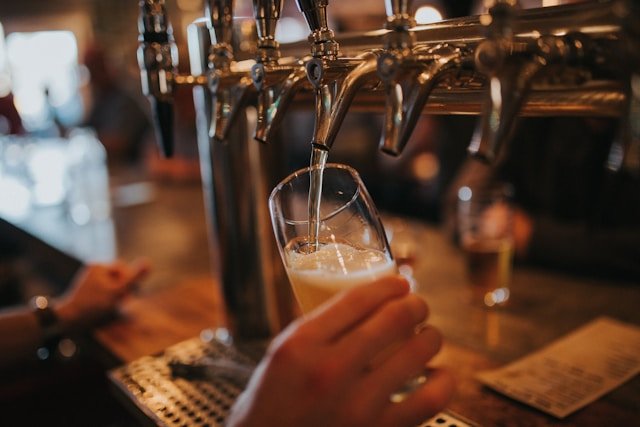 Beer being tapped into a glass at a bar.
