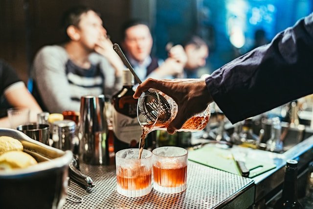 Drinks being poured at a bar.